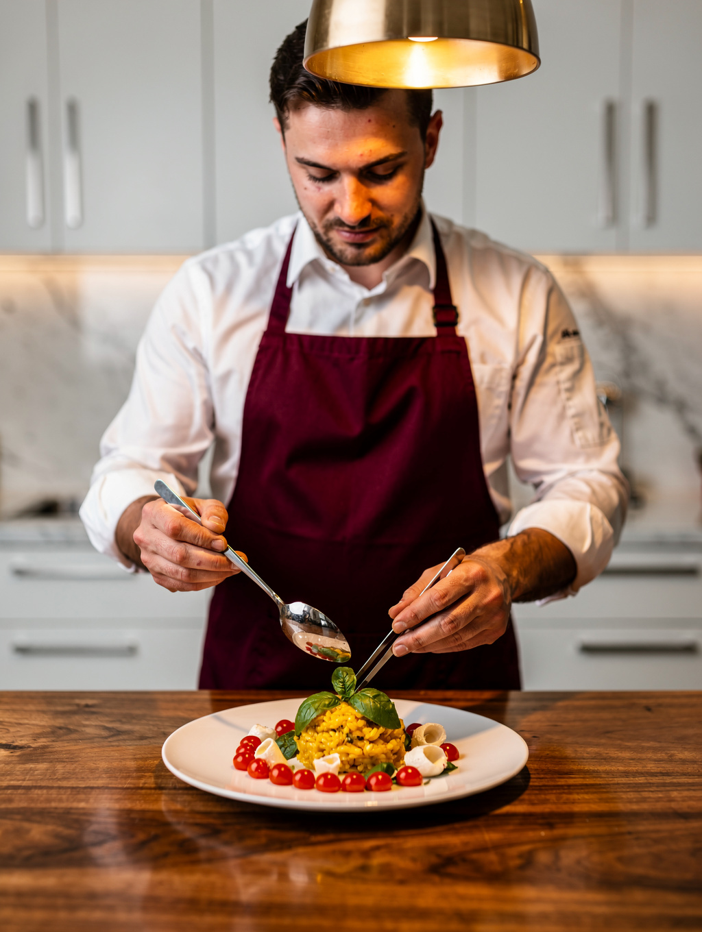 Chef plating a fresh seasonal Italian dish in our kitchen